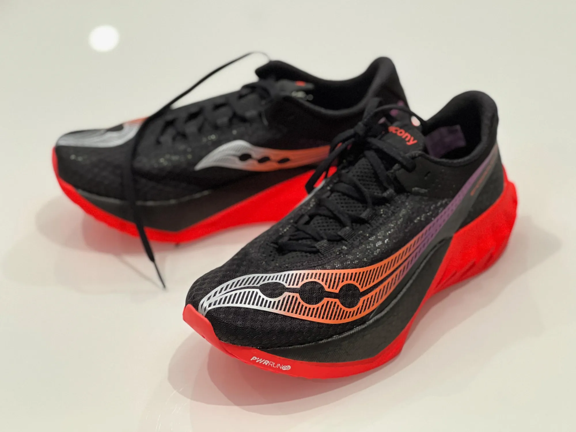 A photo of Saucony Endorphin Pro 4 running shoes, black with red soles